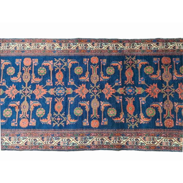 A stunning handmade Persian Kurdish runner rug in rich navy blue with intricate floral and geometric patterns in vibrant orange and cream.