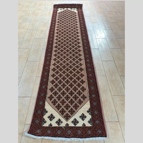 Full view of a handmade Persian Baluch runner with intricate geometric patterns and rich colors