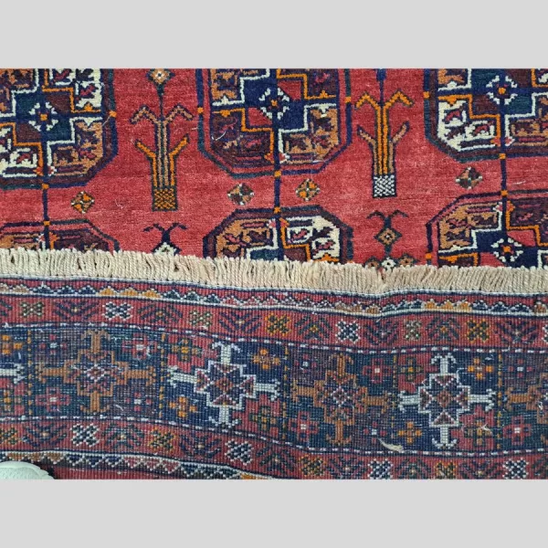 Close-up showing the precise knotting and weave of the Persian Baluch runner.